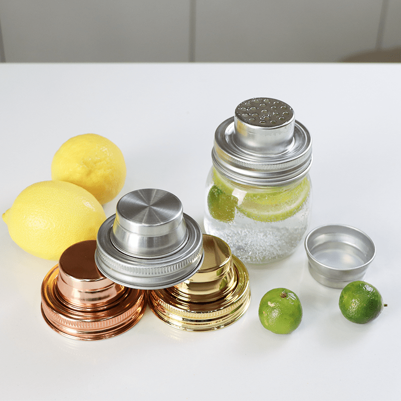 Professional mason jar cocktail shaker lid with built-in strainer, attached to a jar during use.