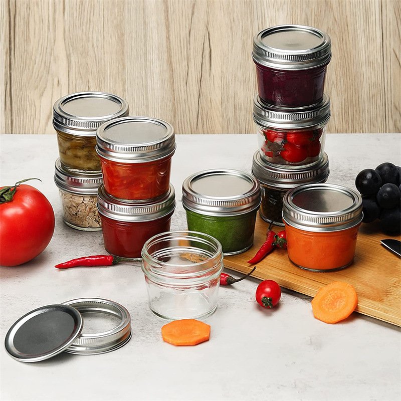 4oz mason jar filled with jam and another as a candle container.